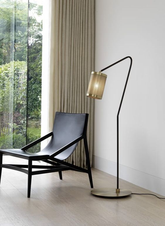 a stylish and refined floor lamp with a metal base and metal net lampshade adds style to the space