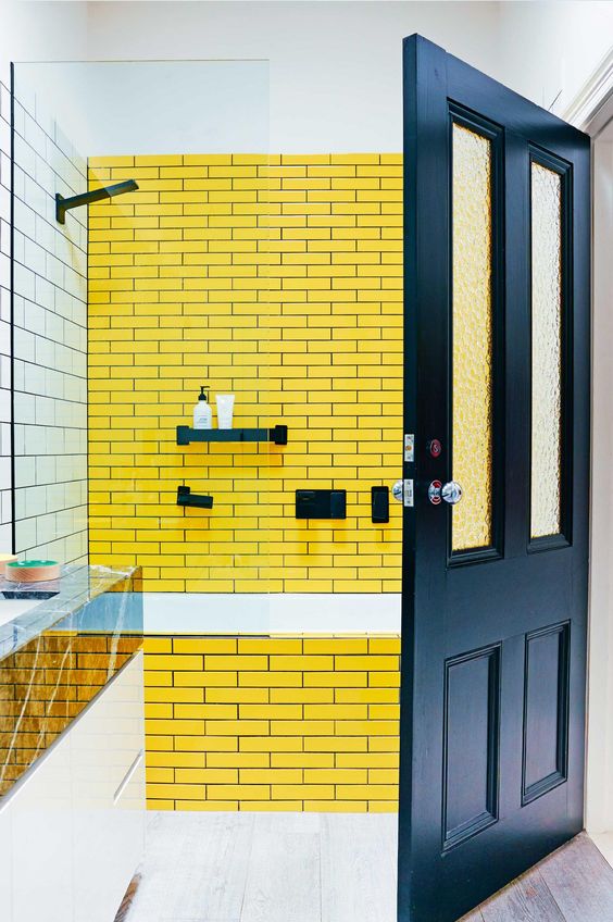 Bold yellow tiles with navy grout and navy fixtures plus a navy door to continue the theme