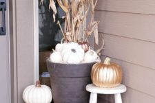 14 fall porch decor with white pumpkins, a gilded one, corn husks and a candle lantern