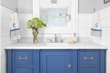 15 a blue vanity with baskets inside and a marble countertop for a coastal farmhouse bathroom