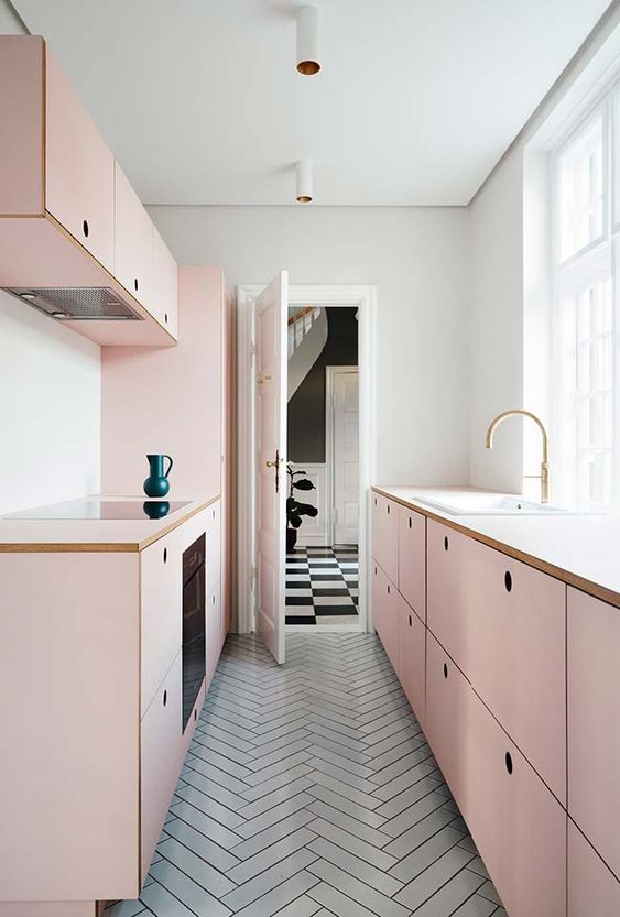 A chic girlish kitchen with simple blush cabinets and a grey tiled floor