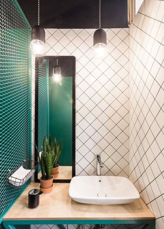 An emerald wall, white tiles with emerald grout and emerald framing of the vanity for a wow look