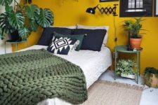 15 green taken in potted greenery and a blanket and a mustard accent wall for a contrast