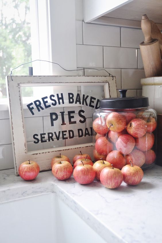 a large jar with apples, faux or real ones, is a simple idea for a kitchen in the fall