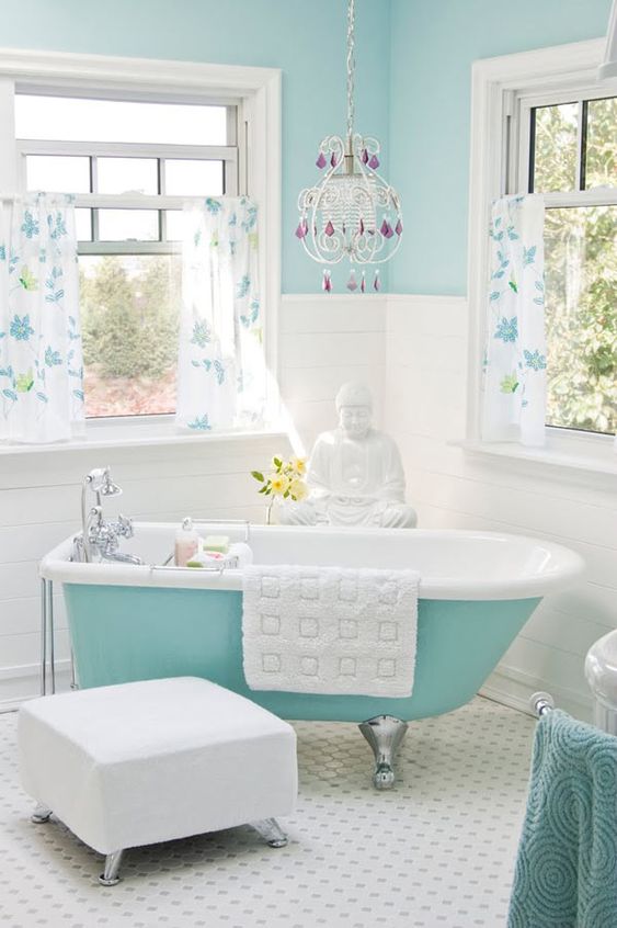 A light blue wall and a turquoise bathtub on silver legs for a chic and eye catchy look in your bathroom