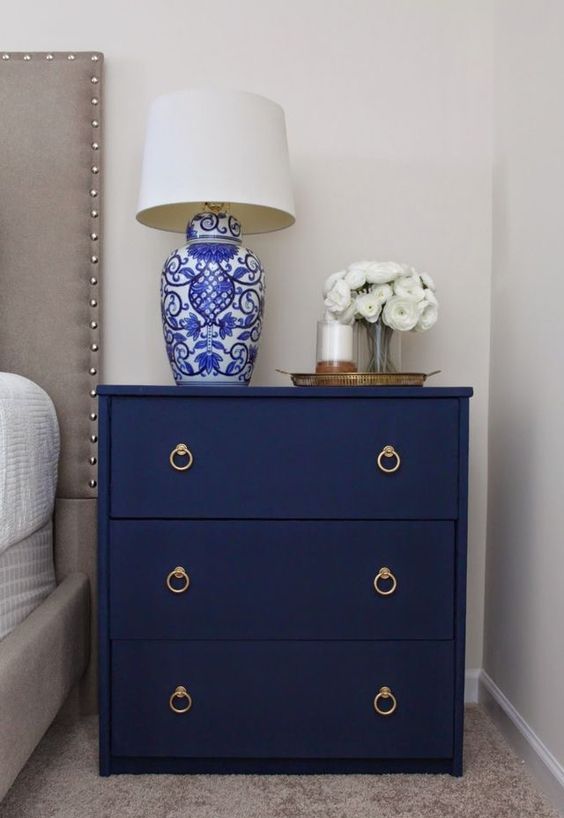 a navy fabric covered nightstand with elegant handles is a chic idea for any bedroom