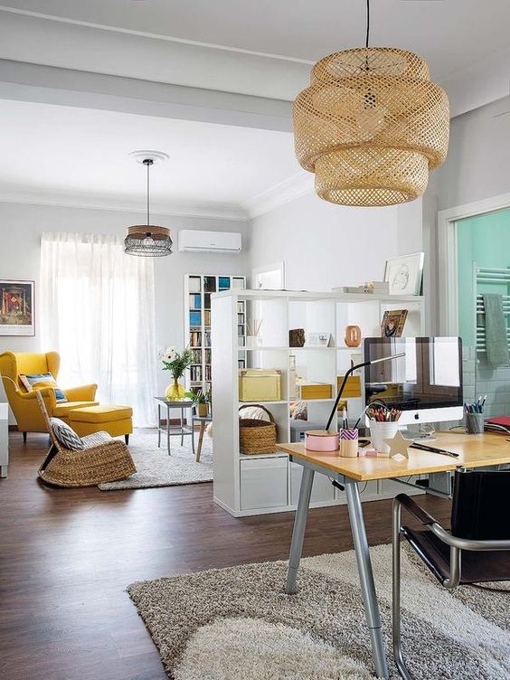 bright yellow touches in both spaces unite the open layout, which is still separated with a shelving unit