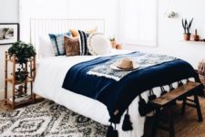 16 potted plants, bold boho pillows and a tassel bedspread are slight touches to make the space boho