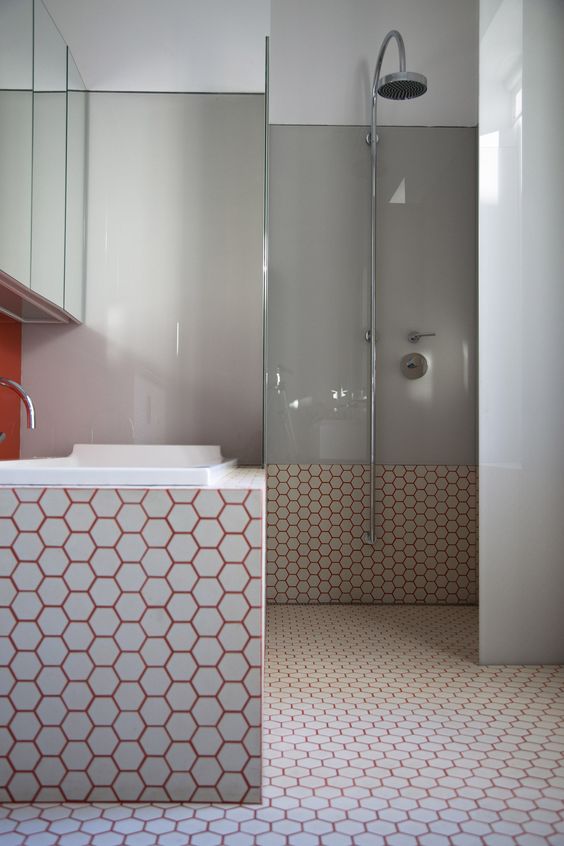 white hexagon tiles spruced up with burnt orange grout and paired with grey for a modern feel