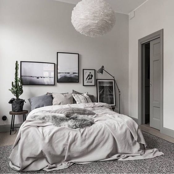 A chic gallery wall in black frames is what makes this grey bedroom eye catchy