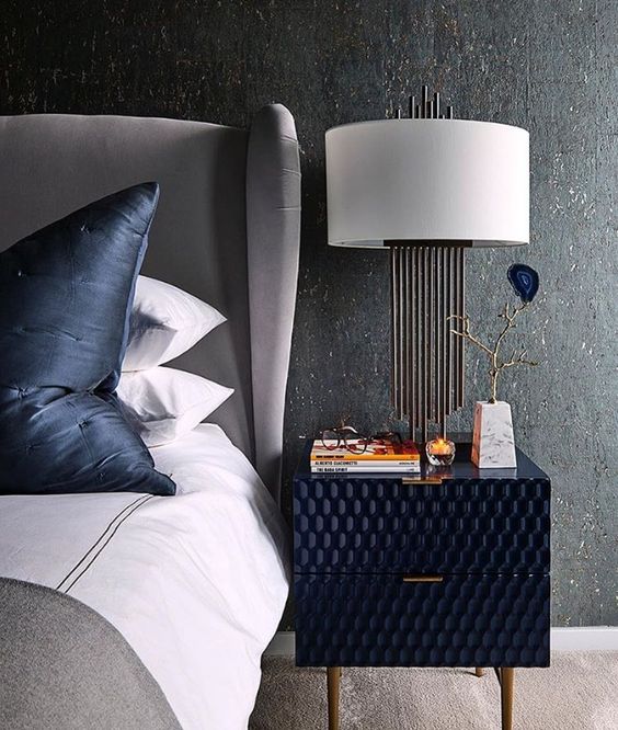 a cool textural navy nightstand adds an interesting touch to the space