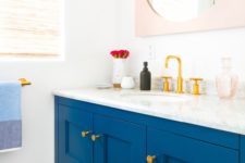 17 an electric blue vanity with molding and brass fixtures to add color to the space
