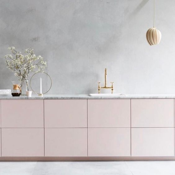 A serene minimalist kitchen with grey plaster walls and blush cabinets is a heavenly beautiful space