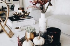 18 a stylish modern fall display with black and white pumpkins with rhinestones, succulents and dried blooms