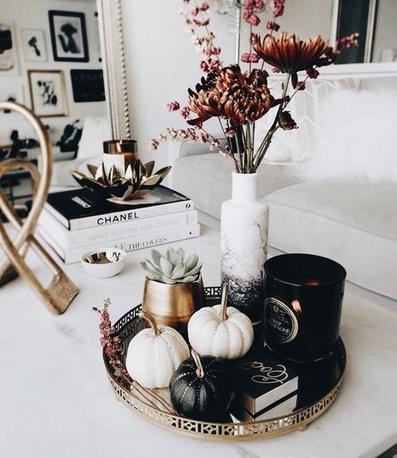 a stylish modern fall display with black and white pumpkins with rhinestones, succulents and dried blooms
