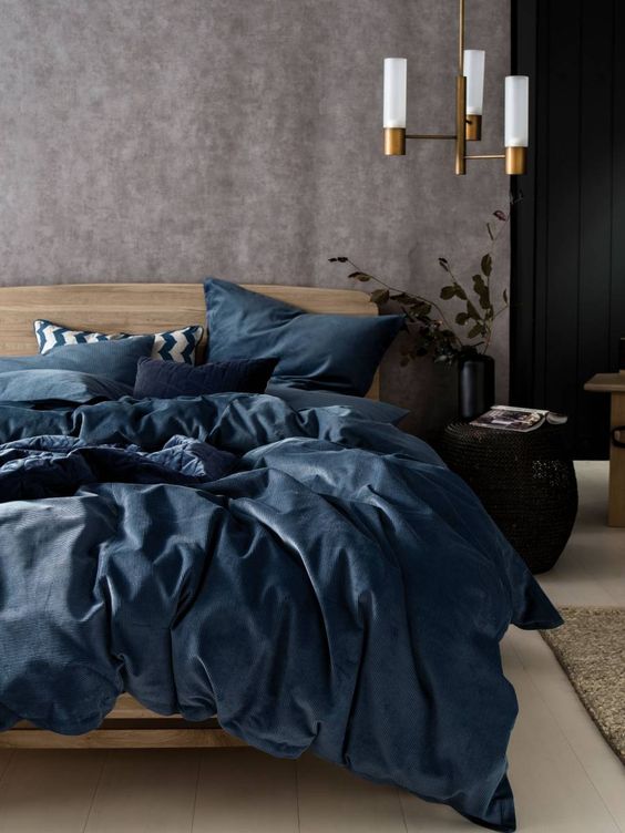 a bedding set in the muted shades of blue spruces up the space done in neutrals