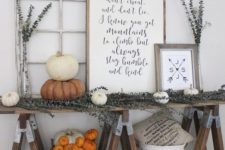 19 a farmhouse trestle table with dried eucalyptus, white and orange pumpkins, signs and baskets