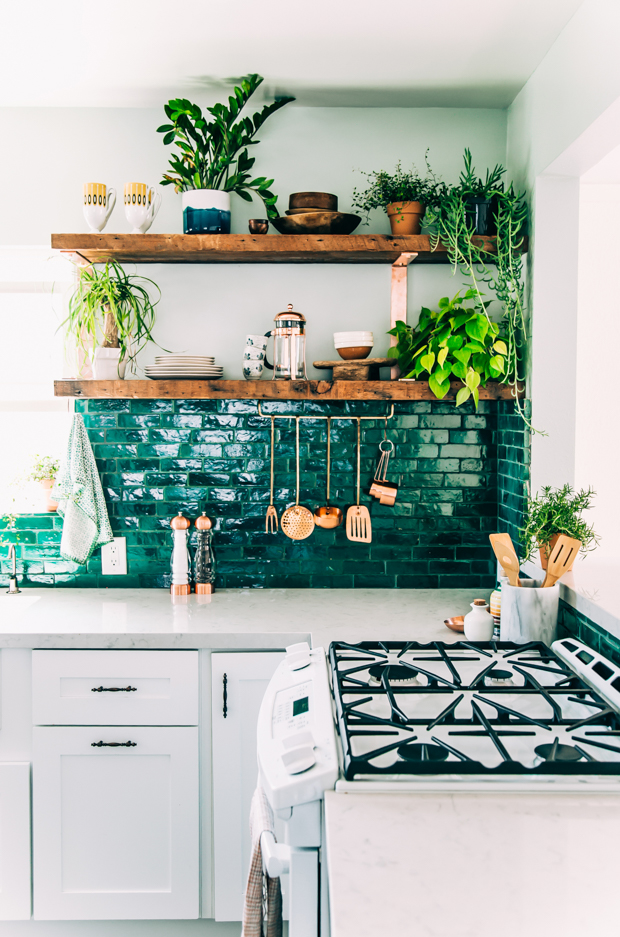 a gorgeous emerald tile backsplash and wooden shelves make up a stunning setup for a boho kitchen