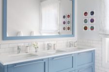 20 a large modern pale blue triple vanity with silver handles and a matching large mirror for a coastal feel