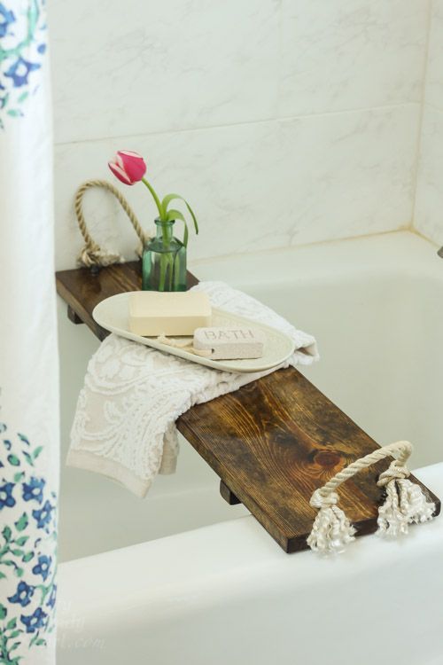 a rustic bathroom caddy of a stained wood piece and thick rope - such an item can be easily DIYed