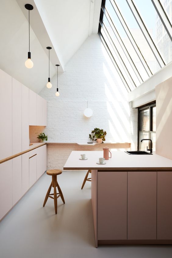 Blush cabinets in a white attic kitchen create a subtle and tender look
