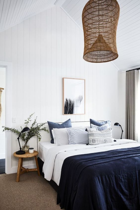 a navy blanket and pillows for adding a touch of color to the neutral space
