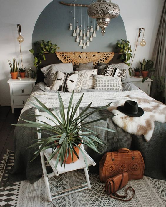 a tassel hanging, potted greenery, faux fur, a jute rug and a silver lamp in Moroccan style