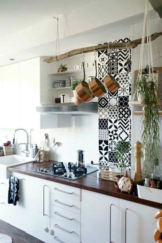 a vertical mosaic tile feature, a tree branch pot holder and cascading greenery in a hanging planter for a boho feel