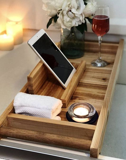 a wooden bath tray with comfy handles and a large gadget or book holder is a very functional piece