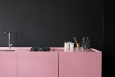 22 bold pink cabinets aoften the black walls and make up a cool and bold combo
