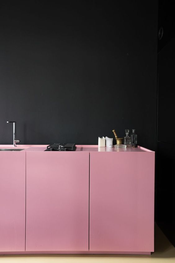 bold pink cabinets aoften the black walls and make up a cool and bold combo