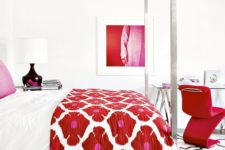 23 a luxurious white bedroom with a hot red chair, artwork and a floral bedspread