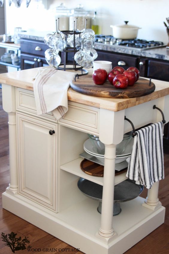 a vintage rustic kitchen island in white with much storage space and a wooden countertop