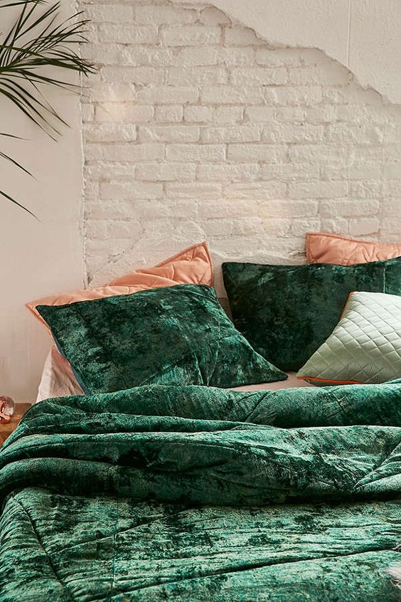 Crushed emerald velvet bedding combined with corals looks super chic and fall like