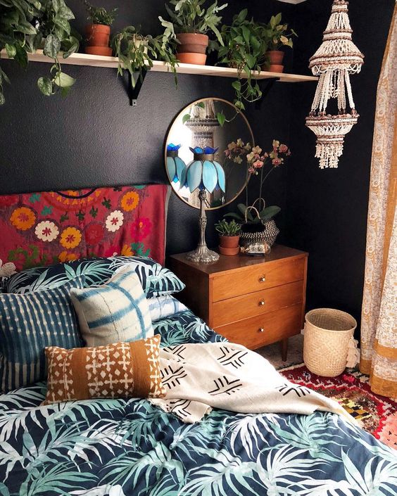 a macrame and bead chandelier, printed textiles and a lot of potted greenery make the space boho