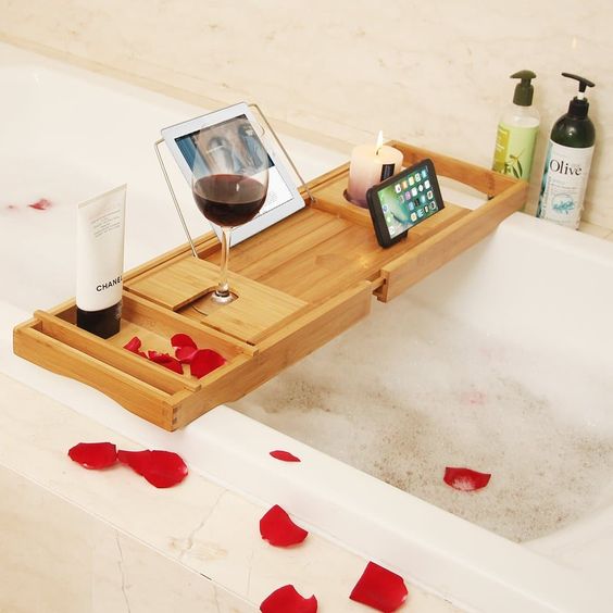 a modern bathroom caddy with a wine glass holder, a candle holder and a gadget stand