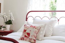 24 a white bedroom with a red metal frame bed and a matching wicker nightstand