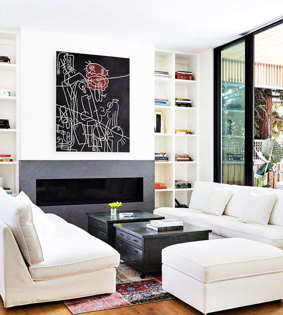 a modern built-in fireplace with comfy white upholstered furniture and a couple of coffee tables