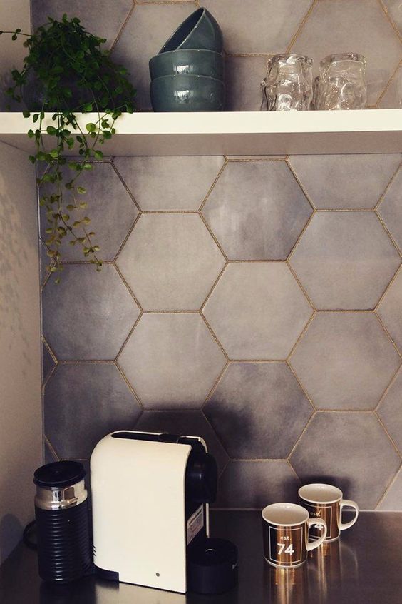 Matte grey hexagon tiles spruced up with gold grout to give it an elegant touch