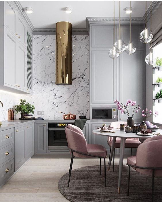 pale pink chairs add color to the monochromatic kitchen with metallic touches