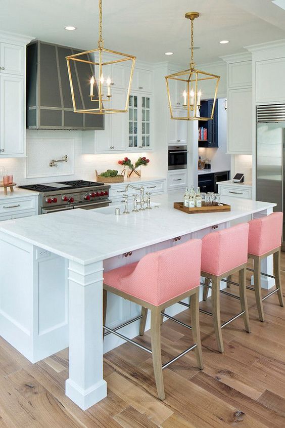 pink stools add color to the traditional kitchen in white and create a modern twist
