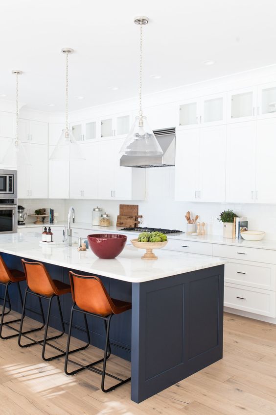white cabinets with a navy kitchen island and a white countertop that echoes with the cabinets themselves