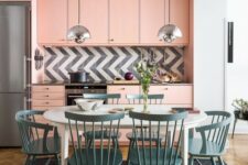 a light pink mid-century modern kitchen with a graphic tile backsplash and a dining zone in blue right here