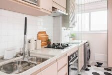 a modern blush kitchen with sleek cabinets, white stone countertops, a white subway tile backsplash and a hex tile floor