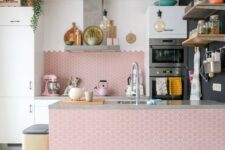 an airy kitchen with white cabinets and a large pink hex tile backsplash and kitchen island is really amazing