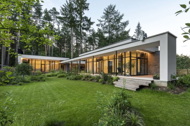 This stylish ontemporary home is located on a forested site and some pines are growing through