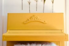 02 a yellow piano with a faux fur stool and faux blooms attached to the wall for a feminine feeling