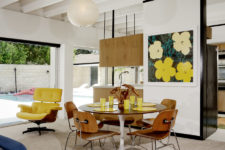 03 The dining space is done with a round table and chairs and a bright artwork and is separated with a narrow wall