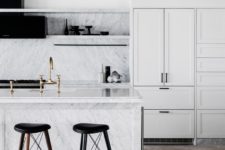 03 The kitchen is done with white cabinets, white marble and black touches for a dramatic feel