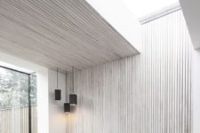 03 a minimalist space is enlivened and made more interesting with a whitewashed paneled wall and ceiling